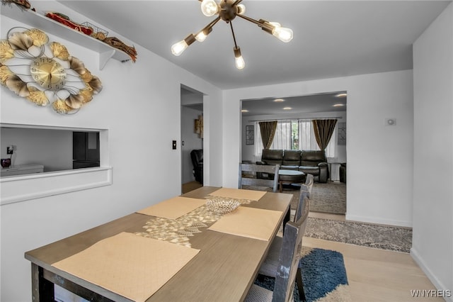 dining area featuring an inviting chandelier and light hardwood / wood-style flooring