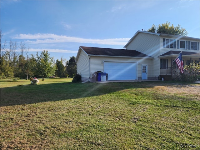 view of side of property with covered porch, a yard, and a garage