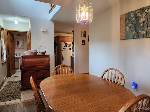 dining area with light hardwood / wood-style floors and a chandelier