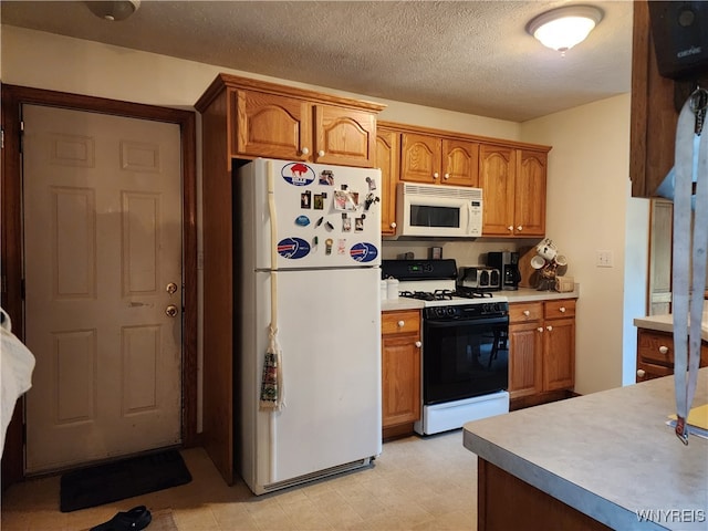 kitchen with a textured ceiling and white appliances