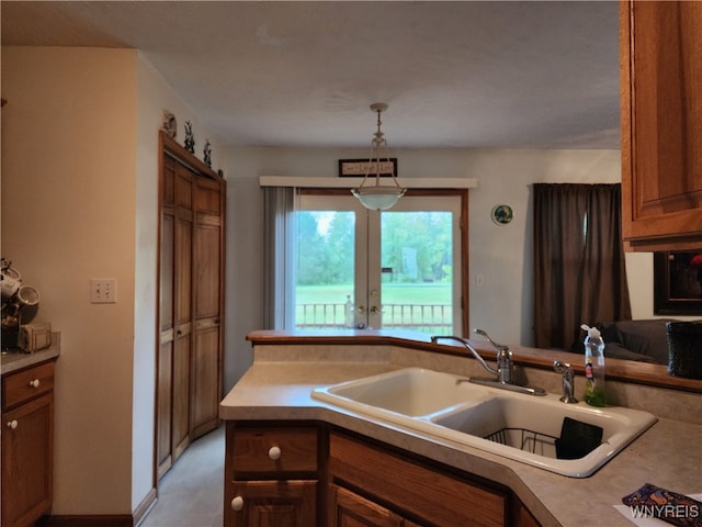 kitchen with french doors, decorative light fixtures, and sink