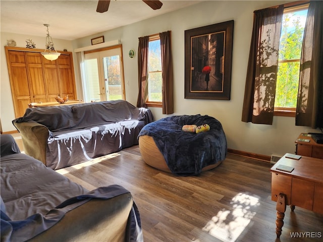 living room featuring a wealth of natural light, french doors, ceiling fan, and dark hardwood / wood-style flooring