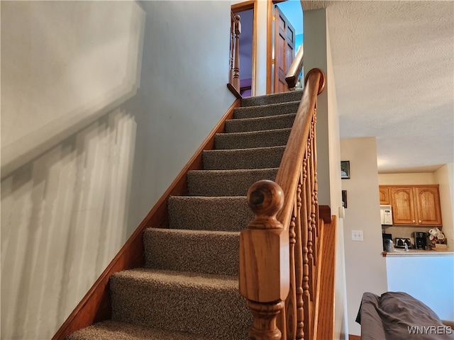 stairway with a textured ceiling