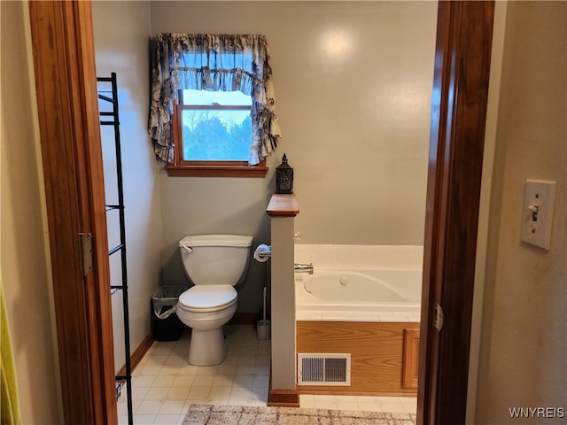 bathroom with toilet, a bath, and tile patterned flooring