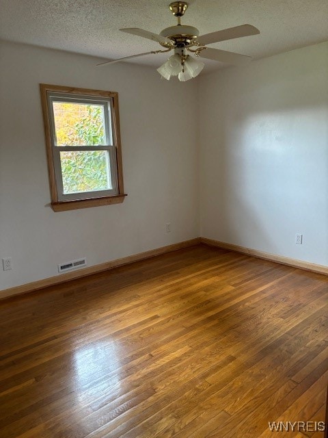 spare room with a textured ceiling, hardwood / wood-style floors, and ceiling fan