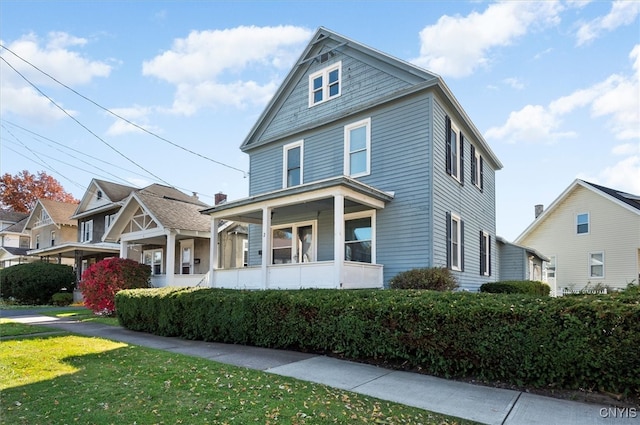 view of front facade with a front yard and covered porch