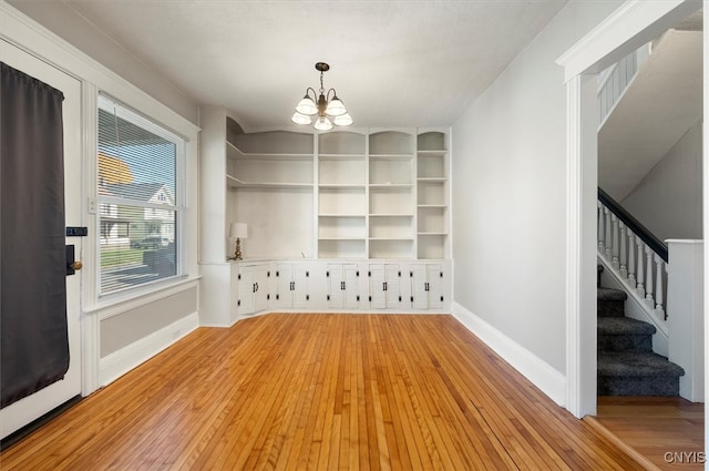 unfurnished dining area with light hardwood / wood-style flooring and a chandelier