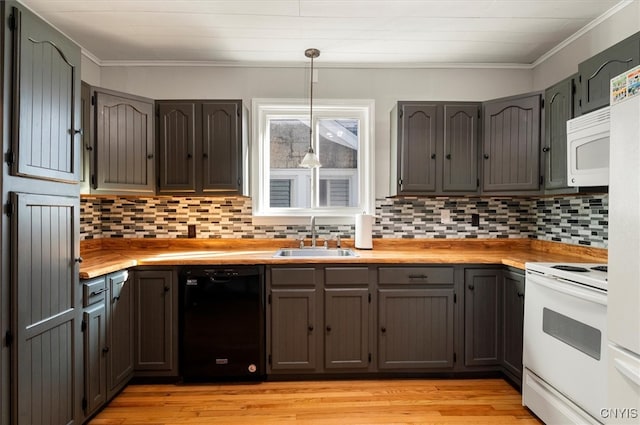 kitchen featuring light wood-type flooring, ornamental molding, white appliances, sink, and hanging light fixtures