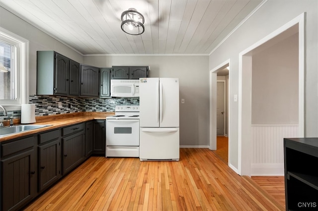 kitchen with sink, backsplash, crown molding, white appliances, and light wood-type flooring