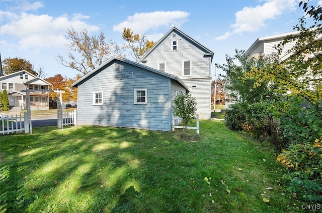 rear view of property featuring a lawn