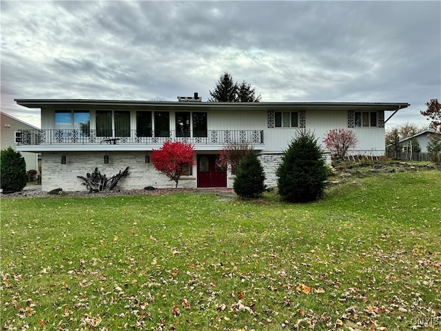 view of front facade featuring a front yard and a balcony