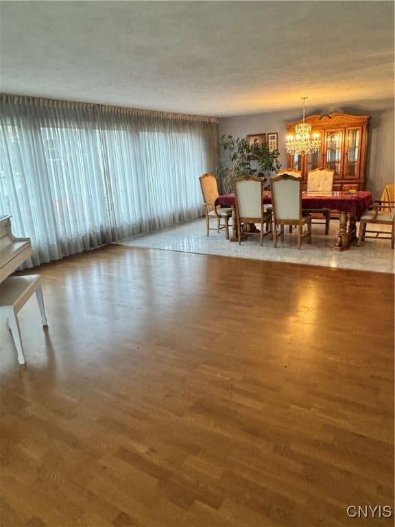 dining area featuring an inviting chandelier, hardwood / wood-style floors, and a textured ceiling