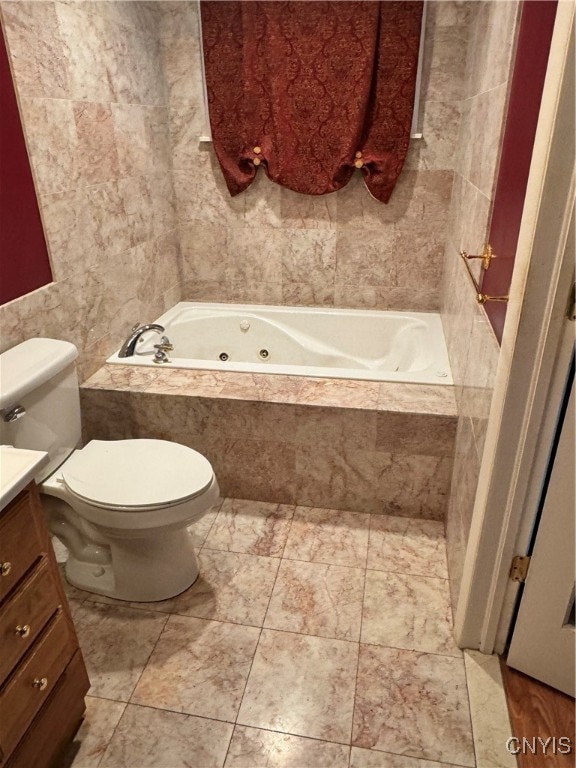 bathroom featuring vanity, tiled tub, and toilet