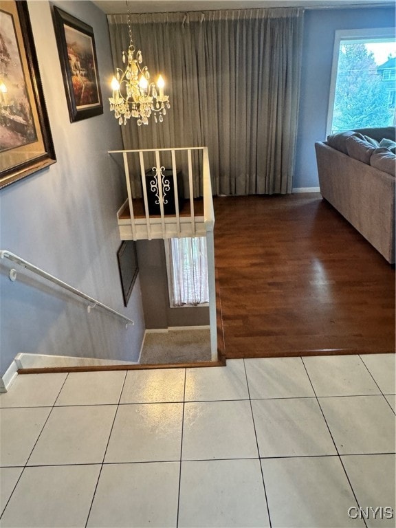 stairs with a chandelier and tile patterned floors