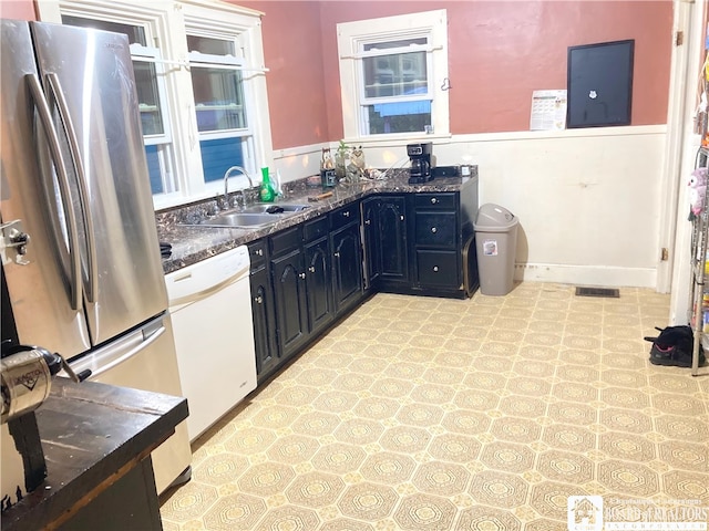 kitchen featuring sink, white dishwasher, and stainless steel refrigerator