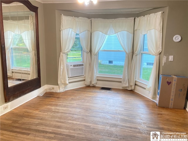 empty room featuring ornamental molding, cooling unit, and hardwood / wood-style flooring