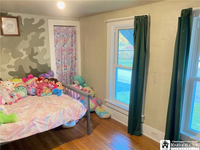 bedroom with multiple windows and wood-type flooring