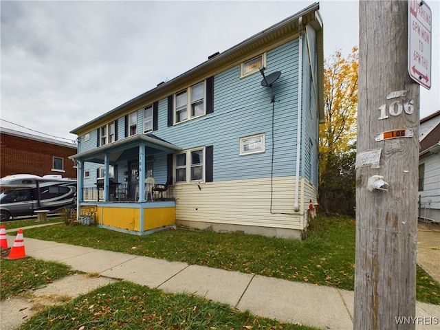 view of front facade with a front yard and covered porch