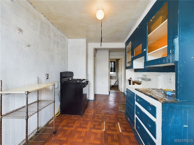 kitchen featuring dark parquet floors, blue cabinets, and black gas range oven