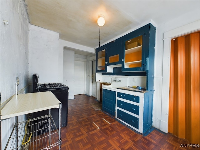 kitchen featuring blue cabinetry, black range oven, and dark parquet flooring