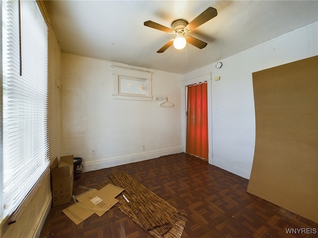 empty room with ceiling fan and dark parquet floors