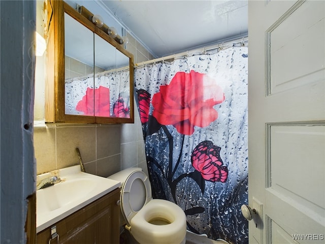 bathroom featuring toilet, curtained shower, vanity, and tile walls