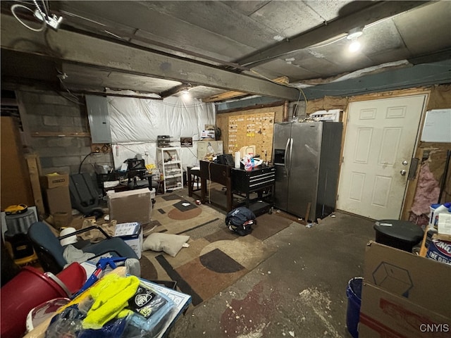 basement with electric panel and stainless steel fridge