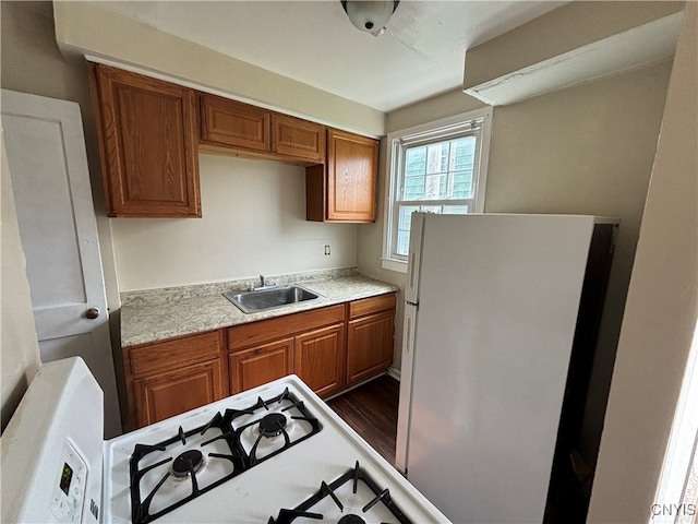 kitchen with white appliances, sink, and dark hardwood / wood-style floors