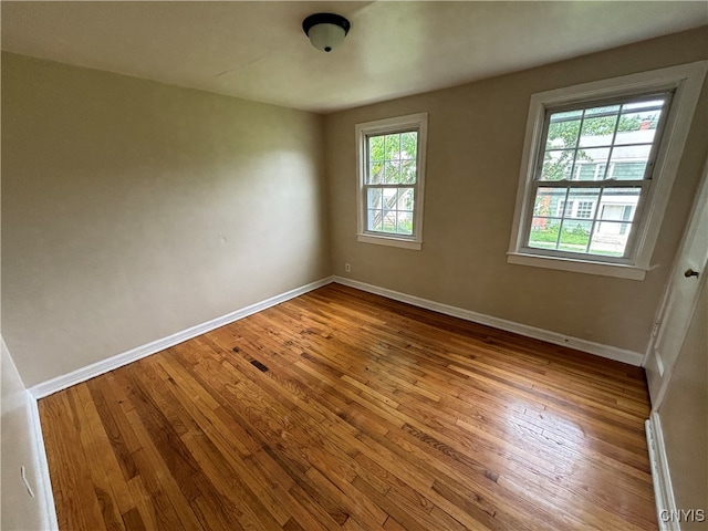 unfurnished room featuring hardwood / wood-style flooring and a healthy amount of sunlight