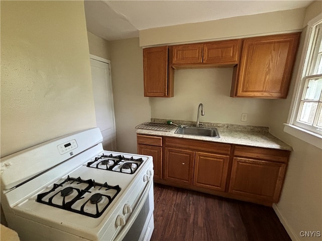 kitchen with dark wood-type flooring, sink, and gas range gas stove