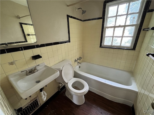 full bathroom with toilet, hardwood / wood-style floors, tiled shower / bath combo, and plenty of natural light