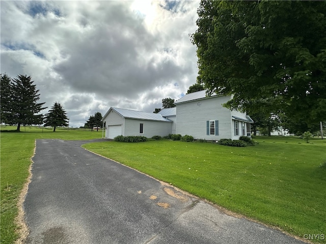 view of front of property with a front yard, an outdoor structure, and a garage