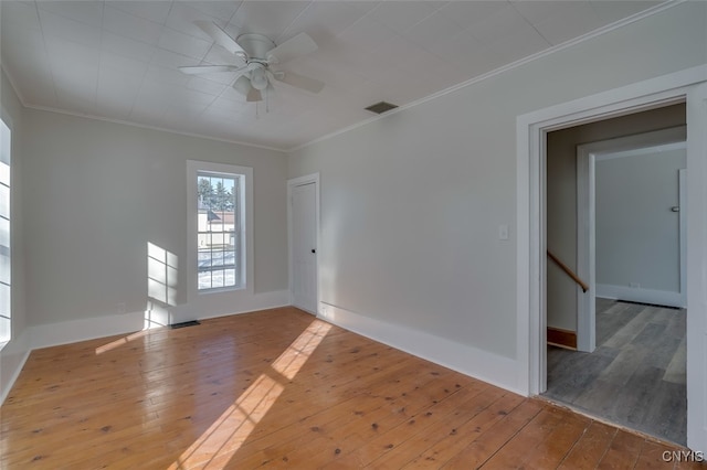 empty room with ornamental molding, light hardwood / wood-style floors, and ceiling fan