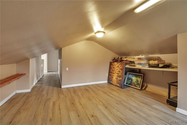 bonus room featuring vaulted ceiling and light wood-type flooring