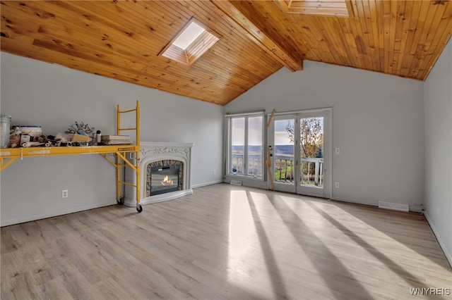 unfurnished living room with beam ceiling, wooden ceiling, light wood-type flooring, high vaulted ceiling, and a skylight