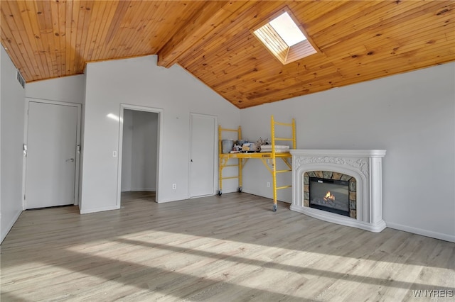 unfurnished living room with light hardwood / wood-style floors, wood ceiling, beamed ceiling, and a skylight