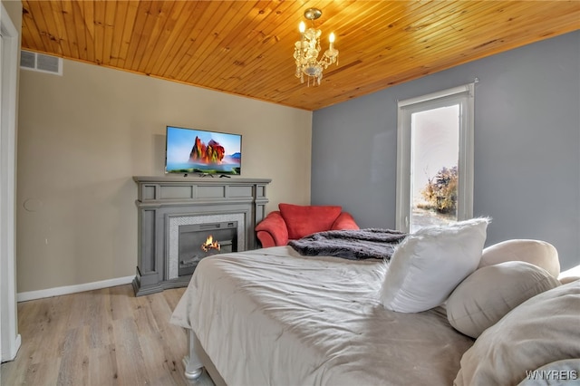 bedroom with a chandelier, light hardwood / wood-style flooring, and wood ceiling