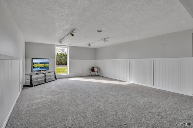 interior space with a textured ceiling and carpet floors