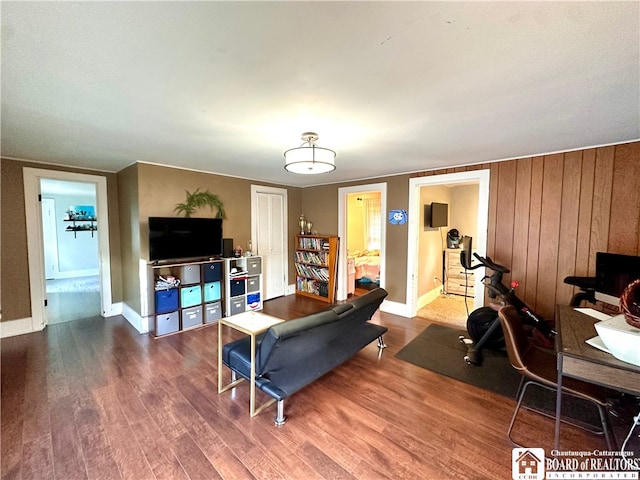 living room with wooden walls and wood-type flooring