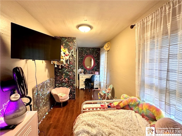 bedroom with lofted ceiling, multiple windows, and dark hardwood / wood-style floors