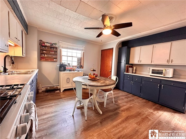 kitchen featuring light hardwood / wood-style floors, white cabinets, sink, and white appliances