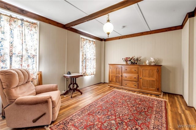 living area featuring light wood-type flooring and wood walls