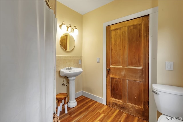 bathroom with toilet, hardwood / wood-style floors, and sink