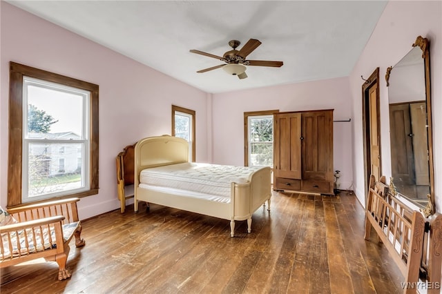 bedroom featuring multiple windows, ceiling fan, and dark hardwood / wood-style flooring