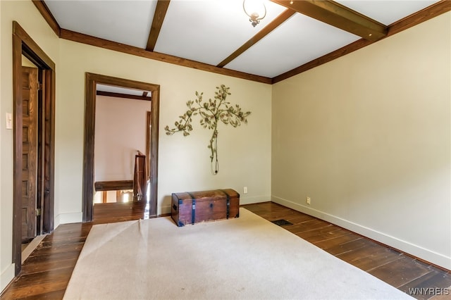 empty room featuring beamed ceiling and dark hardwood / wood-style flooring