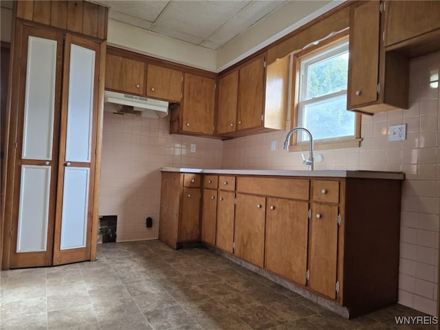 kitchen featuring tile walls and sink