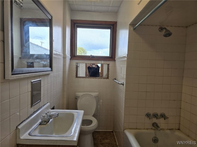 full bathroom featuring tiled shower / bath, tile walls, and toilet