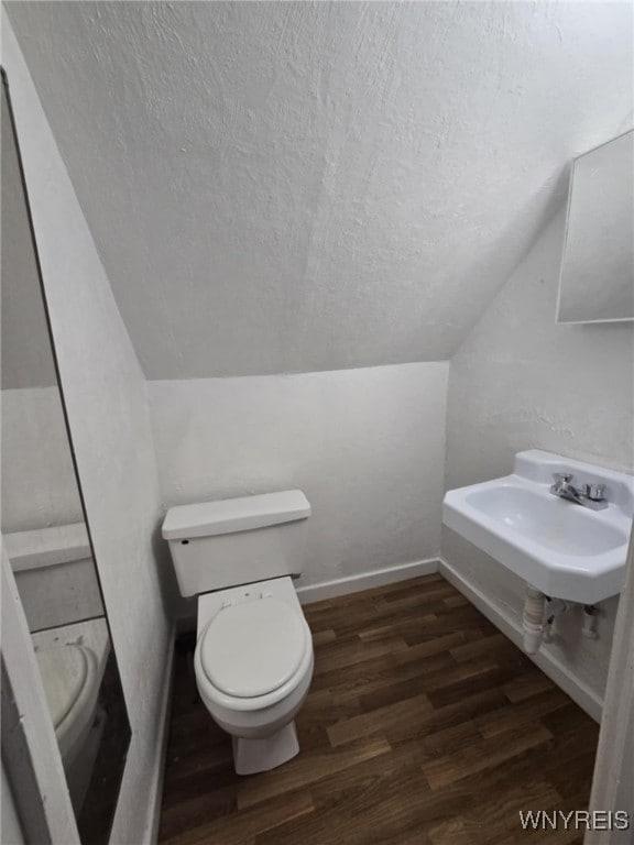 bathroom with vaulted ceiling, wood-type flooring, and toilet