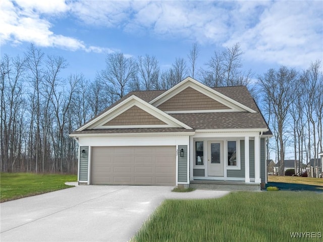 view of front of house featuring a front lawn, concrete driveway, a garage, and roof with shingles