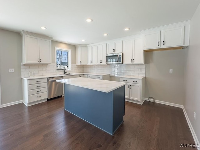 kitchen featuring a sink, backsplash, dark wood-type flooring, and appliances with stainless steel finishes